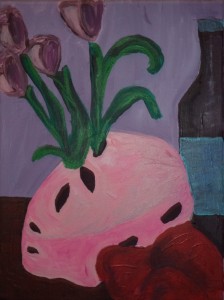 Picture shows a pink helmet right side up and used as a vase. Long stemmed purple tulips rise from two of four almond-shaped ventilation holes at the top of it. Two ventilation holes adorn the front and the side of the helmet. A red pillow-like object with indentations is in front of the helmet. A long necked dark glass bottle with a blue label and blue cap is to the back right of the helmet. The edge of a brown, flat surface, presumably a table, frames the helmet in the bottom left of the painting. The background, appearing to be a wall, is lilac. [end of description] ]