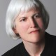 Picture shows Kleege, slightly tilted to the left and slightly facing right. She has silver hair worn in bangs and cut to just below her ears. She wears a black, collarless shirt. [end of description]